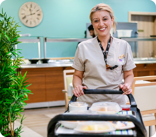 AX Care home employee assisting with meal service